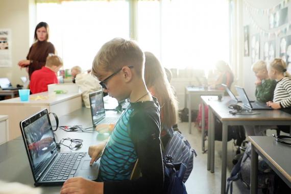Klasserom med barn som sitter på datamaskiner