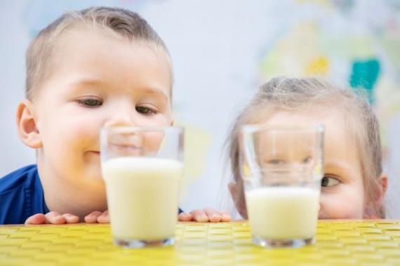 Illustrasjonsbilde av gutt og jente som ser på melkeglass